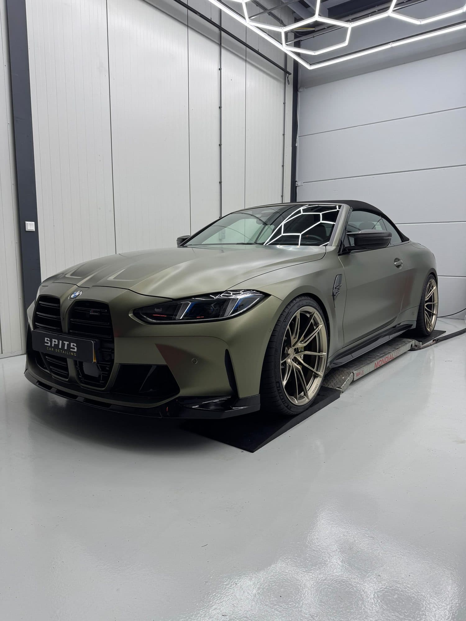 Matte olijfgroene BMW M4 Competition Cabrio in de studio